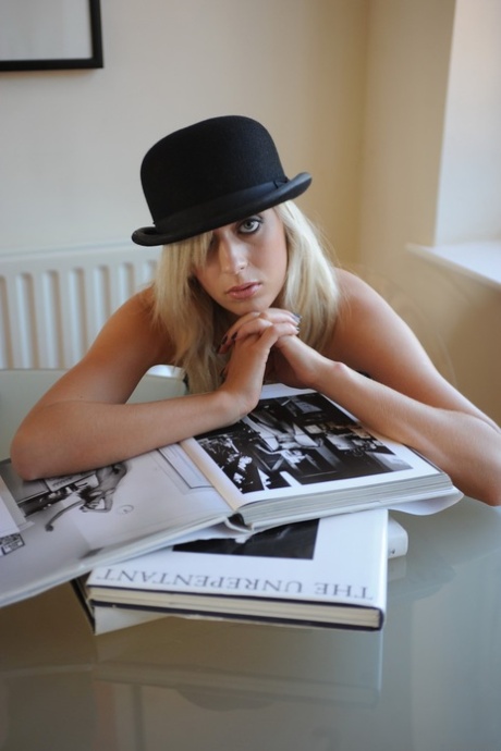 Blonde chick coves her naked pussy with a bowler hat after undressing 12330714
