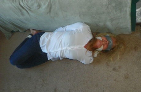 Blonde woman is cleave gagged and hogtied in a white blouse and blue jeans 51524778