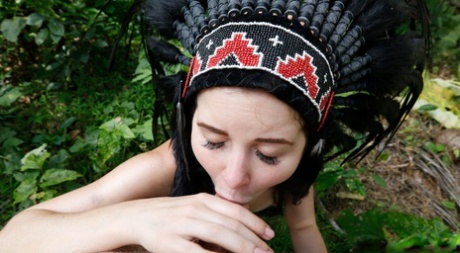 Naked girl Cassie Fire sports a headdress while giving a BJ in the woods 51410885